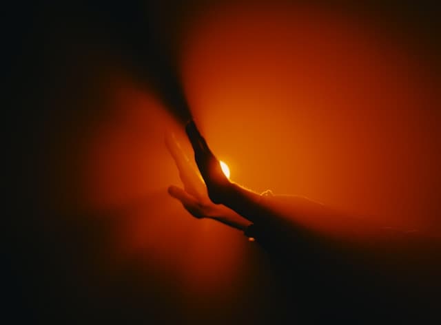 A close up of a person's hand holding a light bulb