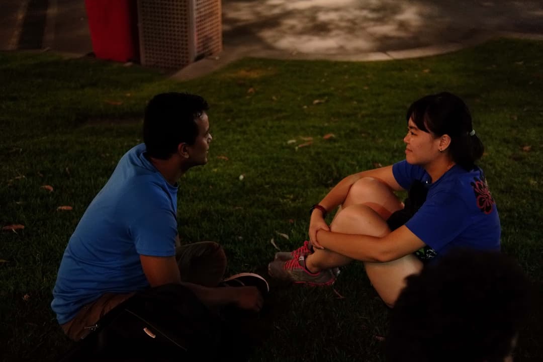 Man and woman sitting on floor in conversation